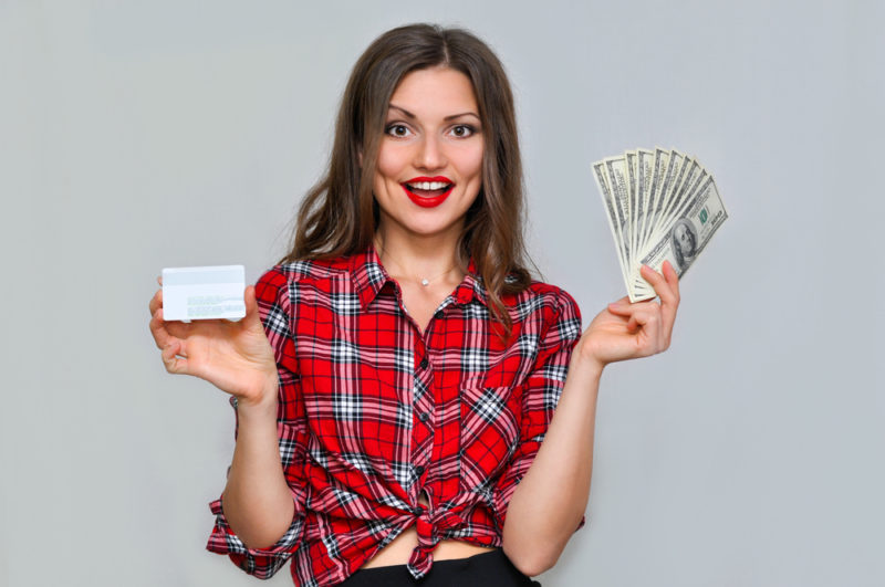 クレジットカードとお札を持つ女性