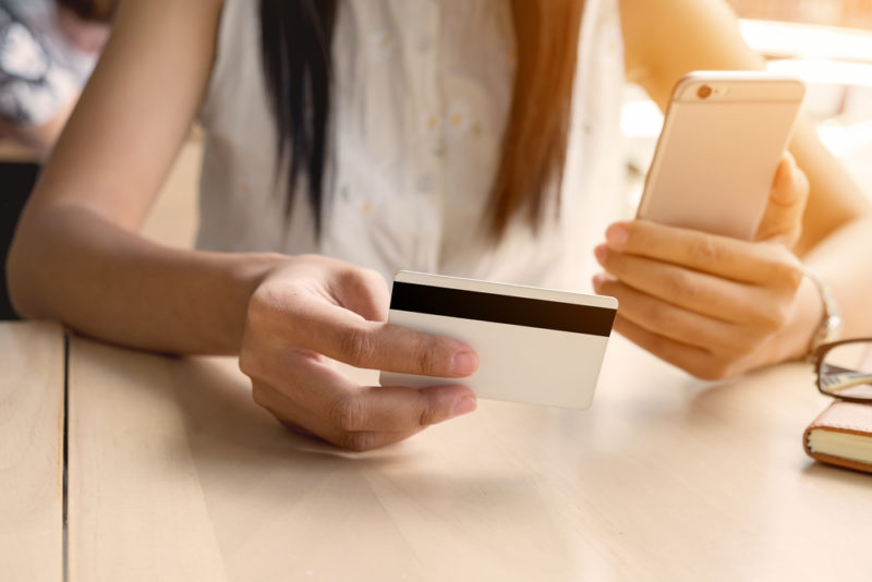 クレジットカードとスマホを持つ女性